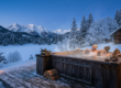 la chaleur du spa en bois fumant au crépuscule, entouré de neige et de forêt, créant l'atmosphère magique décrite dès l'introduction